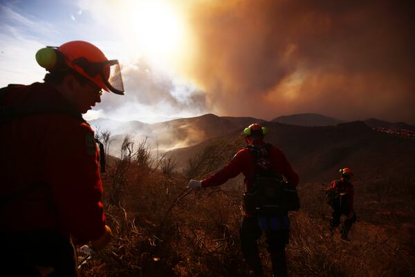 Firefighters work to control the spread of the Hughes Fire in Castaic, Calf., Wednesday, Jan. 22, 2025. (AP Photo/Ethan Swope)