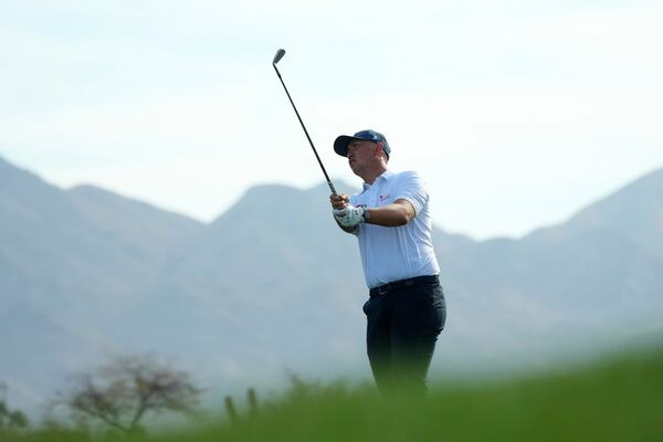 Rico Hoey, of the Philippines, hits an approach shot at the 13th hole during the second round of the Phoenix Open golf tournament at the TPC Scottsdale Friday, Feb. 7, 2025, in Scottsdale, Ariz. (AP Photo/Ross D. Franklin)