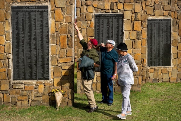 Visitors at the Nampo agricultural fair, one of the largest in the southern hemisphere, check names on the wall of remembrance, a tribute to farmers killed since 1961, near Bothaville, South Africa, May 15, 2025. (AP Photo/Jerome Delay)