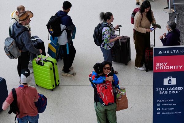 Travelers wait in line to check-in their luggage at San Francisco International Airport ahead of the Memorial Day holiday weekend in San Francisco, Thursday, May 22, 2025. (AP Photo/Godofredo A. Vásquez)