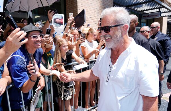 FILE - Mel Gibson, right, interacts with crowd members as he leaves a Hollywood Walk of Fame star ceremony for actor Vince Vaughn, on Aug. 12, 2024, in Los Angeles. (AP Photo/Chris Pizzello, File)