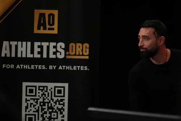 Jim Cavale speaks during a players association for college athletes meeting ahead of the college football's national title game, Saturday, Jan. 18, 2025, in Atlanta. (AP Photo/Brynn Anderson)