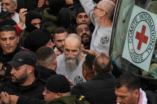 Palestinian Raed Al-Saadi, 57, center, and another prisoners are greeted by a crowd after being released from Israeli prison following a ceasefire agreement with Israel, in the West Bank city of Ramallah, Saturday, Jan. 25, 2025. (AP Photo/Mahmoud Illean)