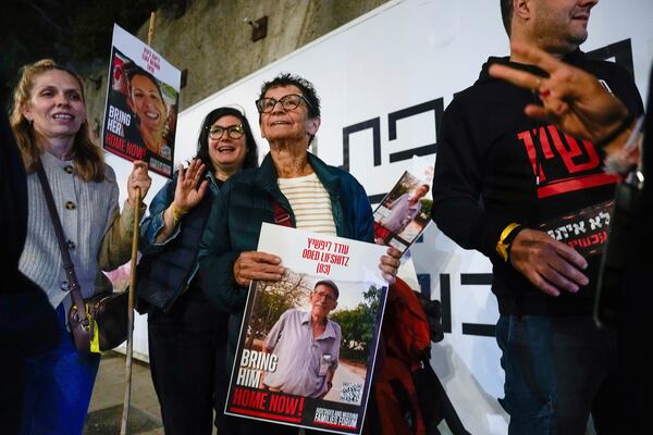 FILE - Yocheved Lifshitz, 85, center, a former hostage who was released from captivity by Hamas last month, holds a photo of her husband, Oded Lifshitz, during a protest calling for the release of hostages still held in the Gaza Strip, in Tel Aviv, Israel, Nov. 28, 2023. (AP Photo/Ariel Schalit, File)