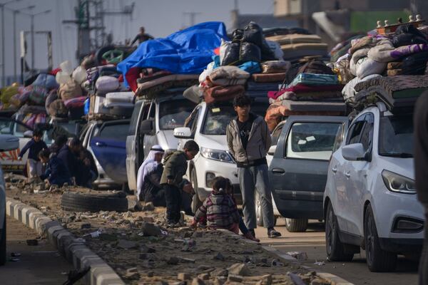 Displaced Palestinians with their belongings gather near a roadblock on Salah al-Din Street, as they wait to return to their homes in the northern part of the Gaza Strip, Sunday, Jan. 26, 2025, days after the ceasefire deal between Israel and Hamas came into effect. (AP Photo/Abdel Kareem Hana)