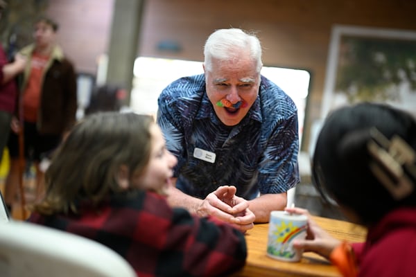 Camp director Dave Mann, center, chats with a child and her volunteer counselor at Camp Boggy Creek, where children with serious illnesses and their families are provided with a free camp experience, Saturday, Jan. 11, 2025, in Eustis, Fla. (AP Photo/Phelan M. Ebenhack)