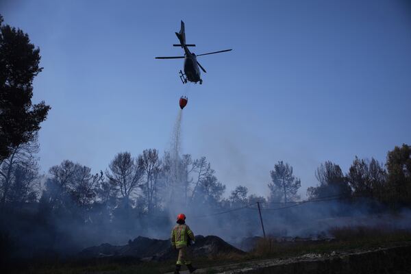 An Israeli fire crews member battles a wildfire in Latrun, Israel, outside of Jerusalem Thursday, May 1, 2025. (AP Photo/Ohad Zwigenberg)