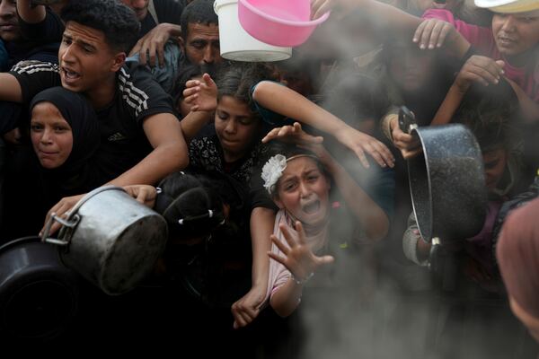 FILE.- A Palestinian girl struggles as she and others try to get donated food at a distribution center in Beit Lahiya, northern Gaza Strip, Sunday, March 16, 2025. (AP Photo/Abdel Kareem Hana,File)