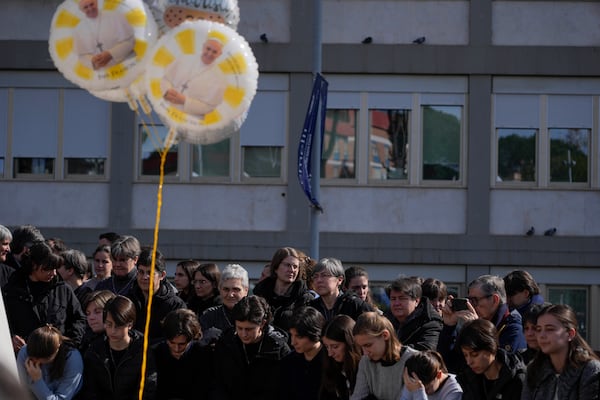 People pray outside the Agostino Gemelli Polyclinic in Rome, Sunday, Feb. 23, 2025, where Pope Francis is hospitalized since Feb. 14. (AP Photo/Gregorio Borgia)