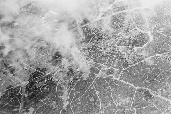 In this photo provided by the U.S. Air Force, plumes of smoke, rising 15,000 feet in the air several hours after Tokyo was hit by a force of more than 300 Marianas-based Superfortresses of the 21st Bomber Command, March 10, 1945, show the effect of the heavy bombing which burned out huge areas near the Imperial Palace (right, center). (AP Photo/U.S. Air Force)