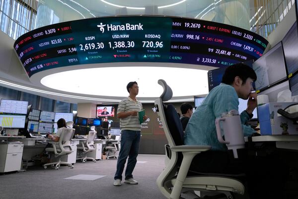 Currency traders work near a screen showing the Korea Composite Stock Price Index (KOSPI), top center left, and the foreign exchange rate between U.S. dollar and South Korean won, top center, at the foreign exchange dealing room of the KEB Hana Bank headquarters in Seoul, South Korea, Wednesday, May 21, 2025. (AP Photo/Ahn Young-joon)