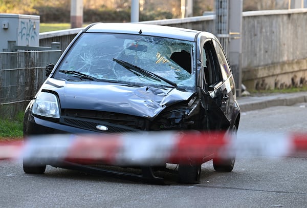 A damaged vehicle stands on an access road to the Rhine bridge, in Mannheim, Germany, Monday, March 3, 2025, following an incident when a car rammed into a crowd, German police said. (Boris Roessler/dpa via AP)