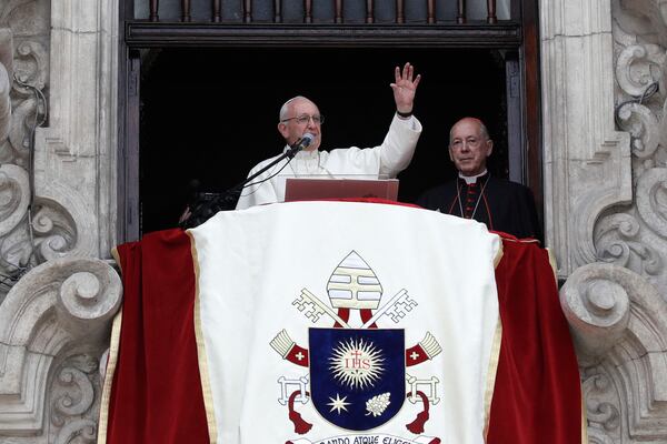 FILE - Pope Francis is flanked at right by Peru's Cardinal Juan Luis Cipriani Thorne, as he waves during the Angelus prayer at Plaza de Armas, in Lima, Peru, Jan. 21, 2018. (AP Photo/Alessandra Tarantino, File)