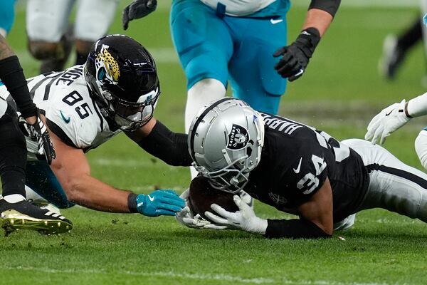 Las Vegas Raiders safety Thomas Harper (34) recovers a rumble against Jacksonville Jaguars tight end Brenton Strange (85) during the first half of an NFL football game Sunday, Dec. 22, 2024, in Las Vegas. (AP Photo/John Locher)