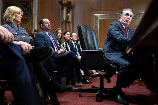 Former Gov. Doug Burgum, President-elect Donald Trump's choice to lead the the Interior Department as Secretary of the Interior, testifies before the Senate Energy and Natural Resources Committee as his wife Kathryn Burgum, left, listens on Capitol Hill in Washington, Thursday, Jan. 16, 2025. (AP Photo/Jose Luis Magana)