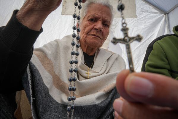 Amal Amouri shows a cross to the photographer at the tent she and her husband Tony Al-Masri, both Christians, share at the Muwassi tent camp near Khan Younis, Gaza Strip on Christmas Day Wednesday Dec. 25, 2024.(AP Photo/Abdel Kareem Hana)