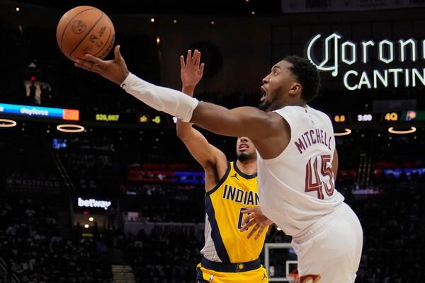 Cleveland Cavaliers guard Donovan Mitchell (45) goes to the basket past Indiana Pacers guard Tyrese Haliburton, left, in the second half during Game 1 in the Eastern Conference semifinals of the NBA basketball playoffs Sunday, May 4, 2025, in Cleveland. (AP Photo/Sue Ogrocki)