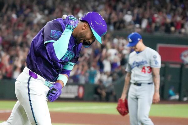 Arizona Diamondbacks outfielder Lourdes Gurriel Jr., left, pumps is fist after hitting a grand slam off of Los Angeles Dodgers pitcher Anthony Banda, right, during the fifth inning of a baseball game Friday, May 9, 2025, in Phoenix. (AP Photo/Darryl Webb)
