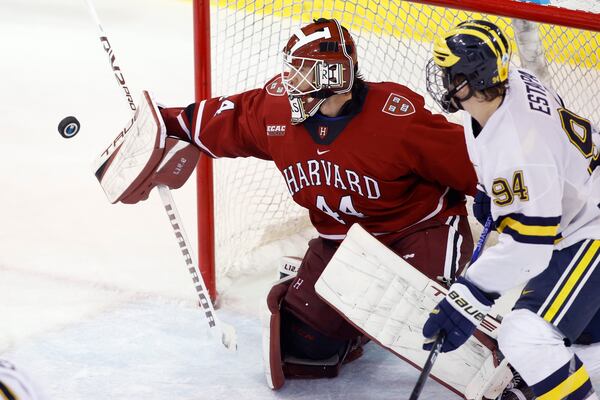 FILE - Harvard goalkeeper Mitchell Gibson, left, deflects the puck against Michigan's Mark Estapa during an NCAA hockey game on Friday, Nov. 25, 2022, in Ann Arbor, Mich. (AP Photo/Al Goldis, File)