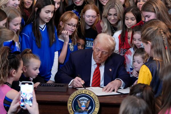 President Donald Trump signs an executive order barring transgender female athletes from competing in women's or girls' sporting events, in the East Room of the White House, Wednesday, Feb. 5, 2025, in Washington. (AP Photo/Alex Brandon)