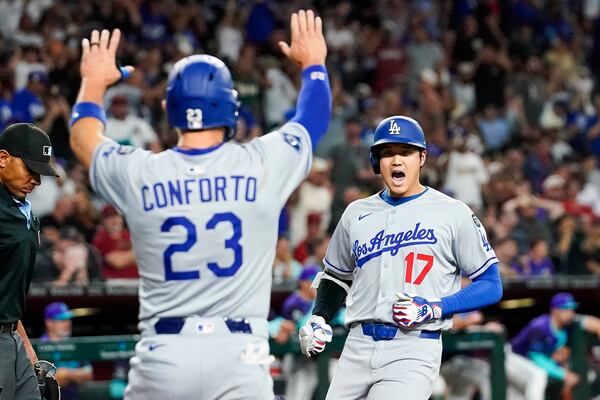 Los Angeles Dodgers' Shohei Ohtani, right, celebrates a three run home run against for the Arizona Diamondbacks during the ninth inning of a baseball game Friday, May 9, 2025, in Phoenix. (AP Photo/Darryl Webb)