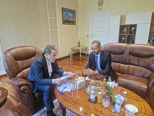 In this photo released by the Iranian Foreign Ministry, Iranian Foreign Minister Abbas Araghchi, left, reads a paper in a meeting with his Omani counterpart Sayyid Badr Albusaidi at the Omani Embassy in Rome during the fifth round of Iran-U.S. negotiations, Friday, May 23, 2025. (Iranian Foreign Ministry via AP)