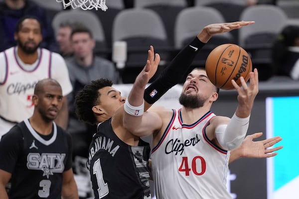 LA Clippers center Ivica Zubac (40) is blocked by San Antonio Spurs center Victor Wembanyama (1) during the first half of an NBA basketball game in San Antonio, Wednesday, Jan. 29, 2025. (AP Photo/Eric Gay)