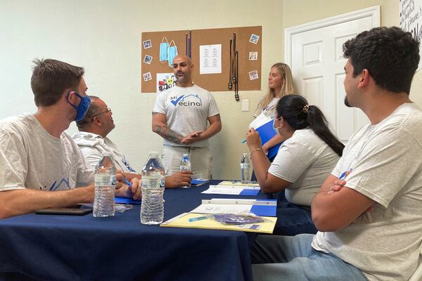 FILE - Alex Berrios, left, and Devon Murphy-Anderson, right, co-founders of the nonprofit Mi Vecino, coach newly hired staff members on how best to approach people and convince them to register to vote on June 24, 2021, in Kissimmee, Fla. (AP Photo/Will Weissert, File)