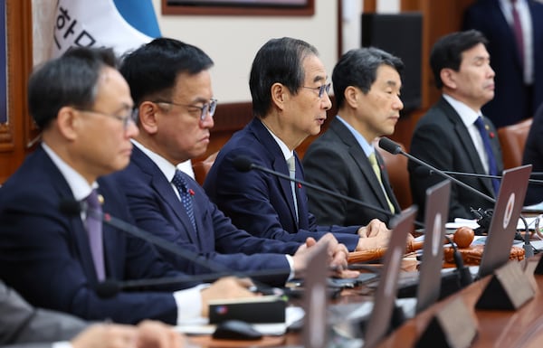 South Korea's Prime Minister Han Duck-soo, center, who became the country's acting leader after President Yoon Suk Yeol's impeachment, speaks during a cabinet meeting at the government complex in Seoul, South Korea, Tuesday, Dec. 24, 2024. (Yonhap via AP)