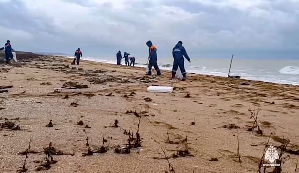 In this photo taken from video released by Russian Emergency Ministry Press Service on Saturday, Jan. 4, 2025, rescuers work to clean up tons of fuel oil that spilled out of two storm-stricken tankers more than two weeks ago in the Kerch Strait, in Russia's southern Krasnodar region. (Russian Emergency Ministry Press Service via AP)