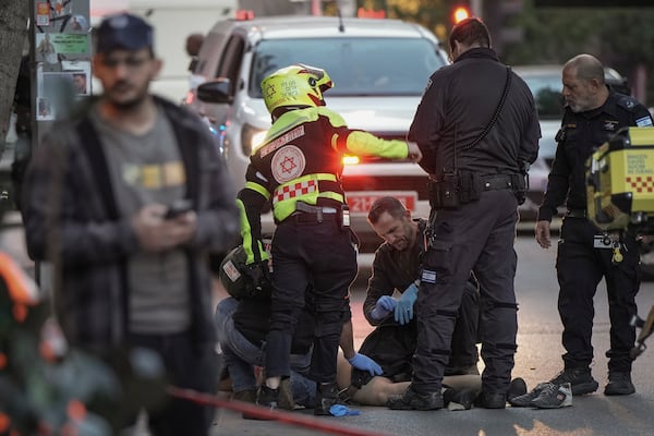 The body of a man who attacked and injured several pedestrians with a knife is examined by Israeli police after he was shot during the stabbing incident in Tel Aviv, Israel, Saturday Jan. 18, 2025.(AP Photo/Oded Balilty)