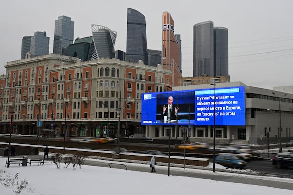 An electronic billboard on a building shows Russian President Vladimir Putin giving his annual news conference and call-in show in Moscow, Russia, Thursday, Dec. 19, 2024, with the Moscow City in the background. (AP Photo/Dmitry Serebryakov)