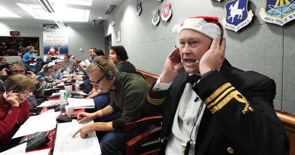 FILE – Canadian Lt. Maj. Chris Hache takes a call while volunteering at the NORAD Tracks Santa center at Peterson Air Force Base in Colorado Springs, Colo., Dec. 24, 2017. (Jerilee Bennett/The Gazette via AP, File)