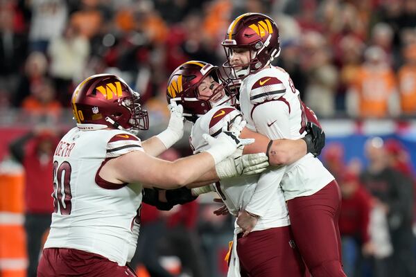 Washington Commanders place kicker Zane Gonzalez, right, is congratulated by teammates after kicking the game winning field goal against the Tampa Bay Buccaneers during the second half of an NFL wild-card playoff football game in Tampa, Fla., Sunday, Jan. 12, 2025. (AP Photo/Chris O'Meara)