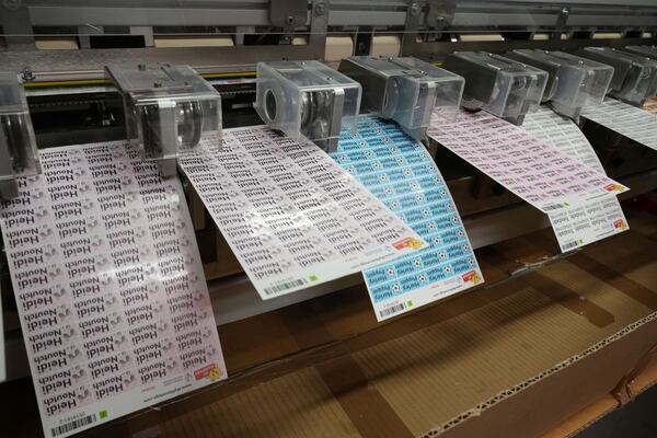 Labels for school children come of the cutting machine at 'My Nametags' factory in London, Thursday, Jan. 30, 2025. (AP Photo/Alastair Grant)