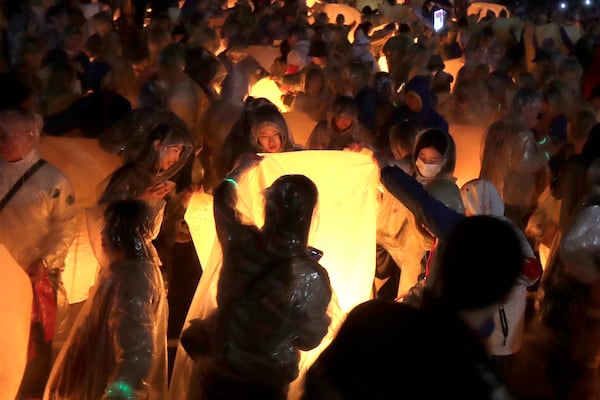 People prepare to release sky lanterns in hopes of good fortune and prosperity in the traditional Lantern Festival in the Pingxi district of New Taipei City, Taiwan, Wednesday, Feb. 12, 2025. (AP Photo/Chiang Ying-ying)