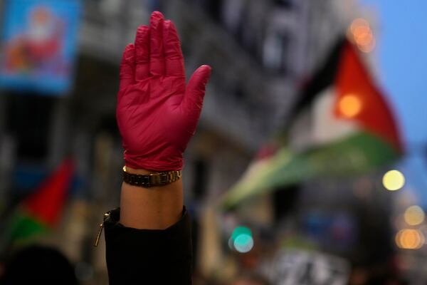 A protester wearing a red glove raises her arm during a demonstration in support of Palestinians in Gaza, in Madrid, Spain, Saturday, Jan. 18, 2025. (AP Photo/Paul White)