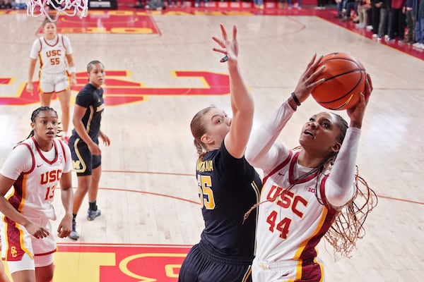 Southern California forward Kiki Iriafen, right, shoots as Michigan center Yulia Grabovskaia defends during the first half of an NCAA college basketball game, Sunday, Dec. 29, 2024, in Los Angeles. (AP Photo/Mark J. Terrill)