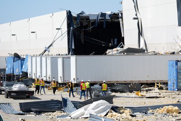 A workers walk outside a damaged warehouse after storms moved through Tuesday, March 4, 2025, in Lewisville, Texas. (AP Photo/LM Otero)