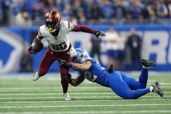 Washington Commanders wide receiver Jamison Crowder (80) breaks the tackle of Detroit Lions safety Brian Branch (32) during the first half of an NFL football divisional playoff game, Saturday, Jan. 18, 2025, in Detroit. (AP Photo/Mike Mulholland)