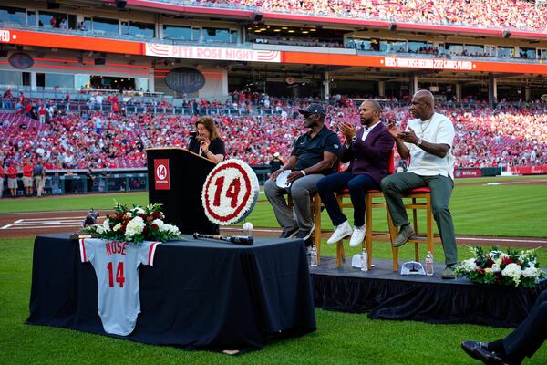 Pete Rose's daughter Fawn Rose speaks as Reds Hall of Fame players, left to right, George Foster, Barry Larkin and Eric Davis listen during Pete Rose Night events before a baseball game between the Cincinnati Reds and the Chicago White Sox, Wednesday, May 14, 2025, in Cincinnati. (AP Photo/Carolyn Kaster)