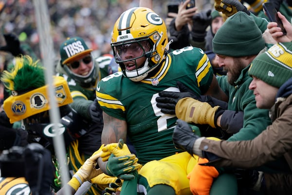 Green Bay Packers running back Josh Jacobs celebrates with fans after scoring against the Chicago Bears during the first half of an NFL football game, Sunday, Jan. 5, 2025, in Green Bay, Wis. (AP Photo/Matt Ludtke)