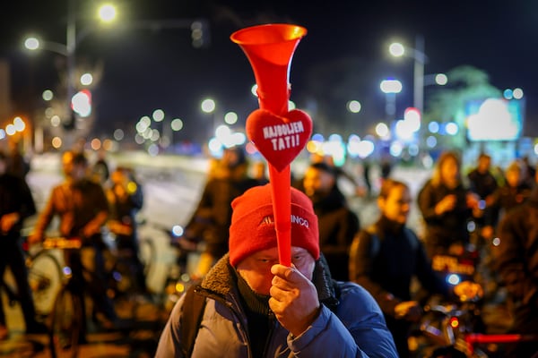 A man blows a horn decorated with a heart that reads "The Best Dad" during a protest over the collapse of a concrete canopy that killed 15 people more than two months ago, in Novi Sad, Serbia, Friday, Jan. 31, 2025. (AP Photo/Armin Durgut)