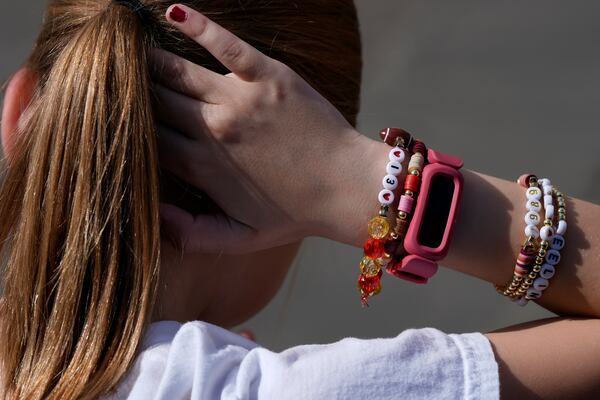 Kansas City Chiefs fan Rose Loftus, 9, from Dallas, ties her hair while wearing a Taylor Swift friendship bracelet outside of St. Louis Cathedral before the NFL Super Bowl 59 football game between the Chiefs and the Philadelphia Eagles, Sunday, Feb. 9, 2025, in New Orleans. (AP Photo/Julia Demaree Nikhinson)