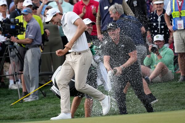 Thomas Detry, left, of Belgium, smiles as he celebrates after his win at the Phoenix Open golf tournament at TPC Scottsdale with fellow golfer Matt Wallace, right, of England, Sunday, Feb. 9, 2025, in Scottsdale, Ariz. (AP Photo/Ross D. Franklin)