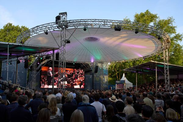 People in Vondelpark watch a video transmission of Ivan Fischer conducting the Budapest Festival Orchestra and the Netherlands Radio Choir performing Mahler's Symphony nr. 2 in the Concertgebouw in Amsterdam, Netherlands, Saturday, May 10, 2025. (AP Photo/Peter Dejong)