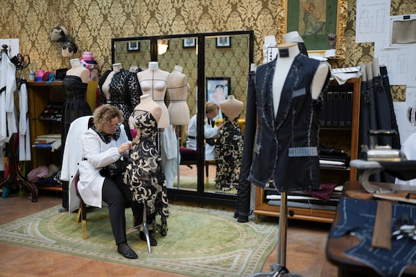 A seamstress works on a dress during the exhibition "From the Heart to the Hands: Dolce&Gabbana" at the Grand Palais, in Paris, Thursday, Jan. 9, 2025. (AP Photo/Thibault Camus)