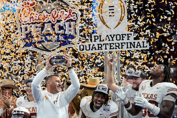 Texas players celebrate victory after a quarterfinals College Football Playoff game against Arizona State, Wednesday, Jan. 1, 2025, in Atlanta. Texas won 39-31 in two overtime periods. (AP Photo/John Bazemore)