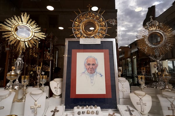 A painting is displayed in a shop window with a message that reads 'Let's pray for Pope Francis' in Rome, Italy Tuesday, Feb. 25, 2025. (AP Photo/Kirsty Wigglesworth)