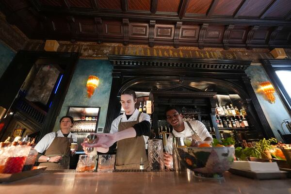 Bartenders mix cocktails at the bar of Columns Hotel on St. Charles Ave., in New Orleans, Friday, Jan. 24, 2025. (AP Photo/Gerald Herbert)